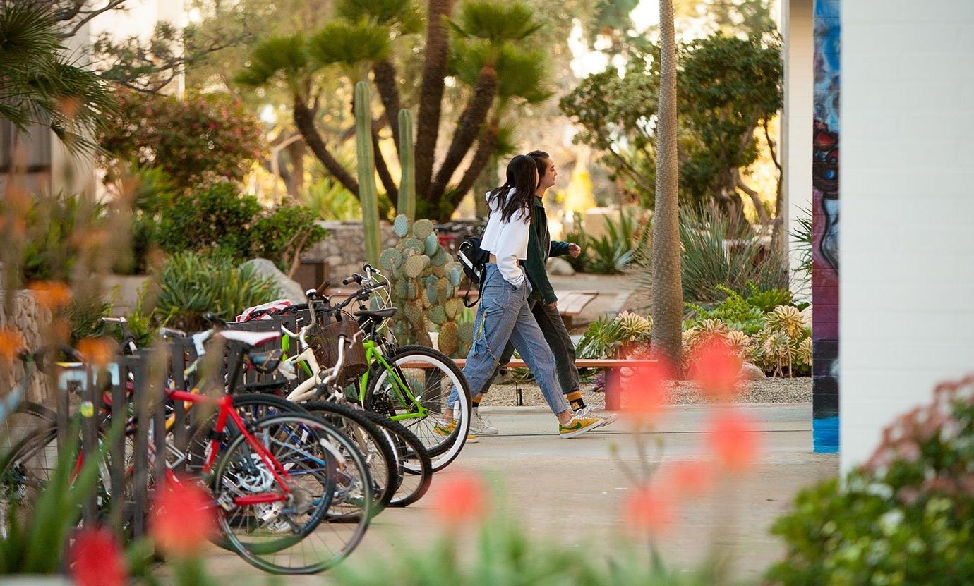 two students walk pas a filled bike rack in mead courtyard